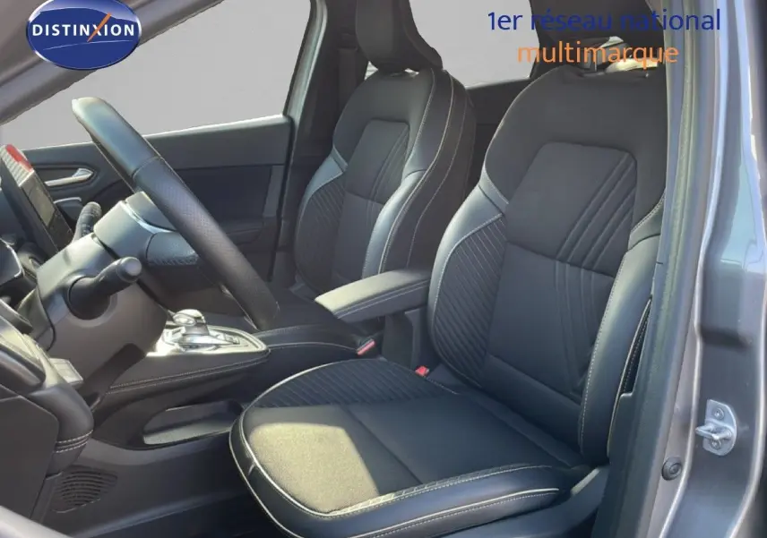 Vue intérieure côté gauche montrant les sièges avant noirs et le volant d'une Renault Symbioz gris cassiopée métal.