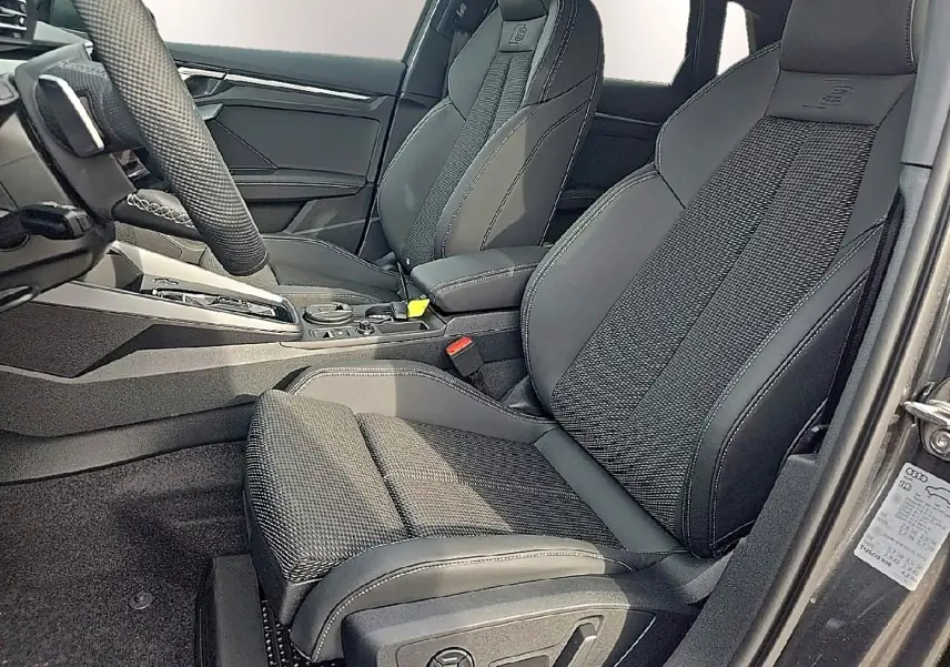 Vue intérieure côté conducteur de l’Audi A3 Sportback 2026 avec sièges sport gris et volant cuir multifonction.