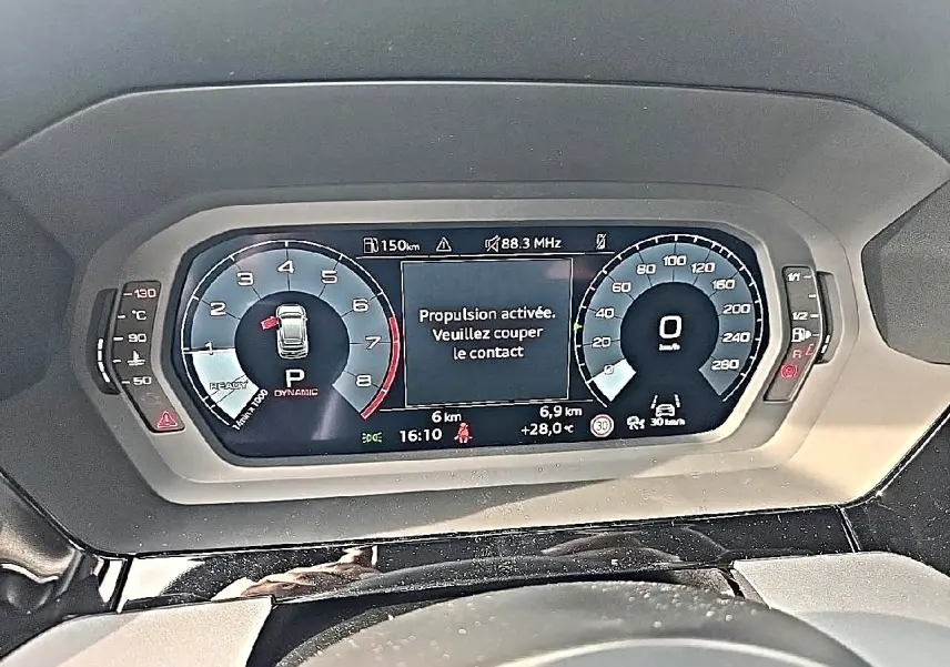 Vue rapprochée du tableau de bord numérique de l'Audi A3 Sportback 2026 affichant la vitesse et un message d'alerte.