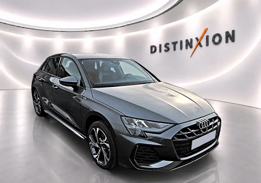 Audi A3 Sportback gris Daytona vue 3/4 avant droit, avec jantes alu et calandre noire distinctive.