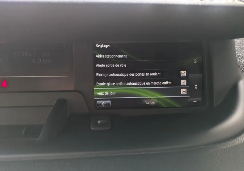 Écran central du tableau de bord du Renault Scenic IV blanc, affichant les réglages d'aides à la conduite.