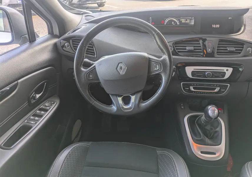 Vue intérieure centrée sur le volant et la console centrale d’un Renault Scenic IV diesel blanc avec boîte manuelle.