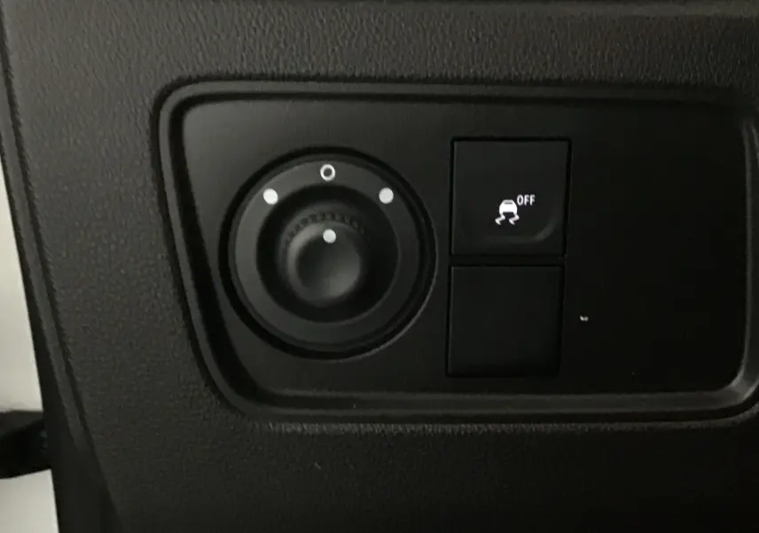 Gros plan sur les commandes noires du tableau de bord du Renault Express Van blanc, avec bouton de contrôle de stabilité activé.