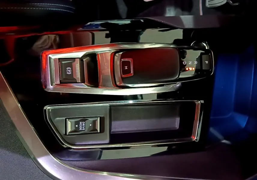 Vue rapprochée de la console centrale noire du Peugeot 3008 2022 avec levier de boîte auto et bouton Drive Mode.