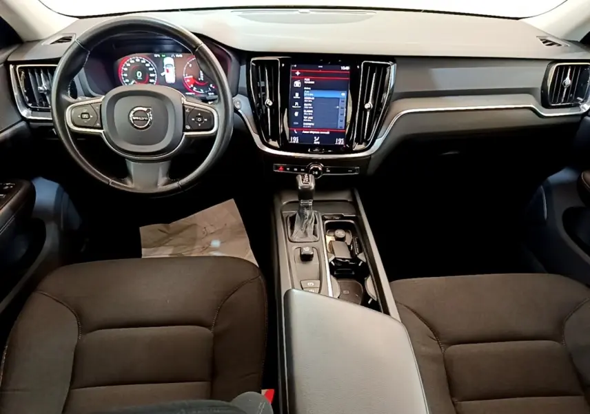 Vue intérieure avant centrée sur le tableau de bord et volant cuir noir de la Volvo V60 D3 Business 2020.