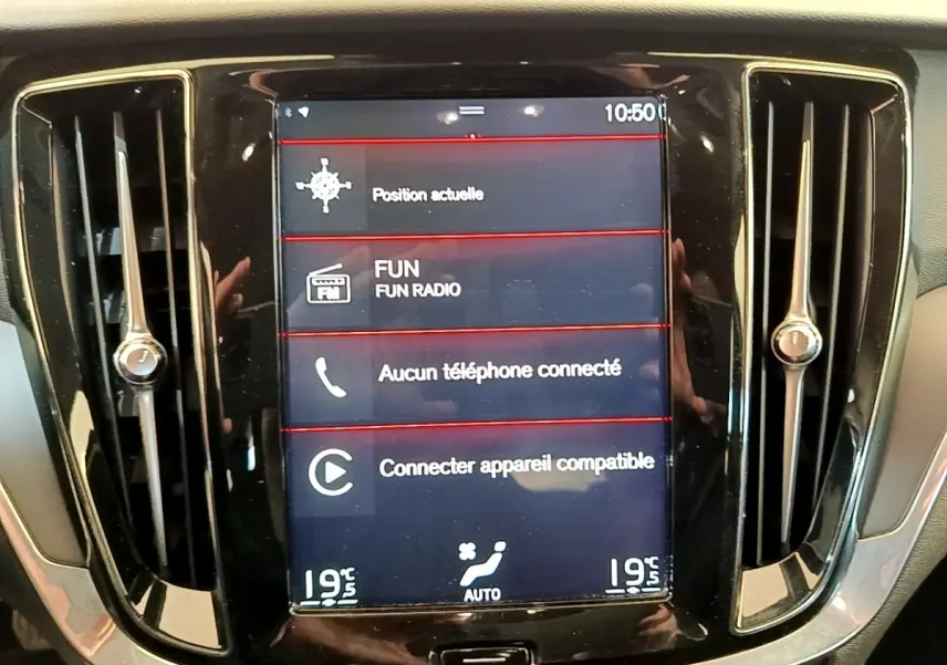 Écran tactile central du tableau de bord noir d'une Volvo V60 D3 Business, affichant la navigation et la radio.