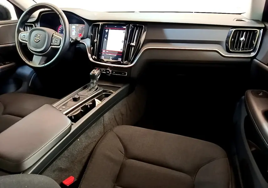 Intérieur noir de la Volvo V60 2020 vu côté conducteur, avec tableau de bord moderne et écran tactile central vertical.