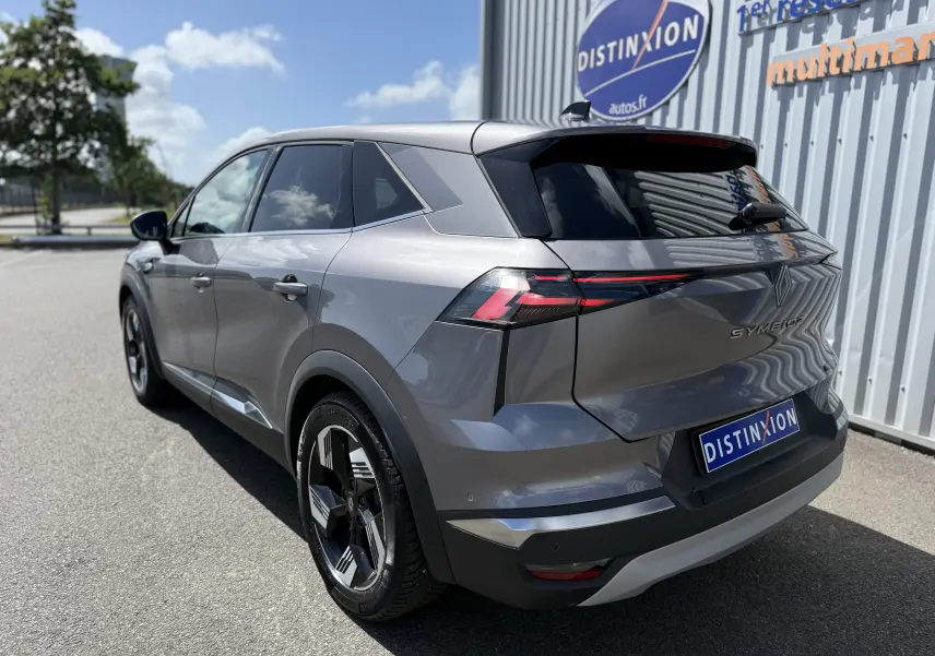 Vue 3/4 arrière droite du Renault Symbioz gris cassiopée métallisé avec feux arrière LED et jantes noires distinctives.