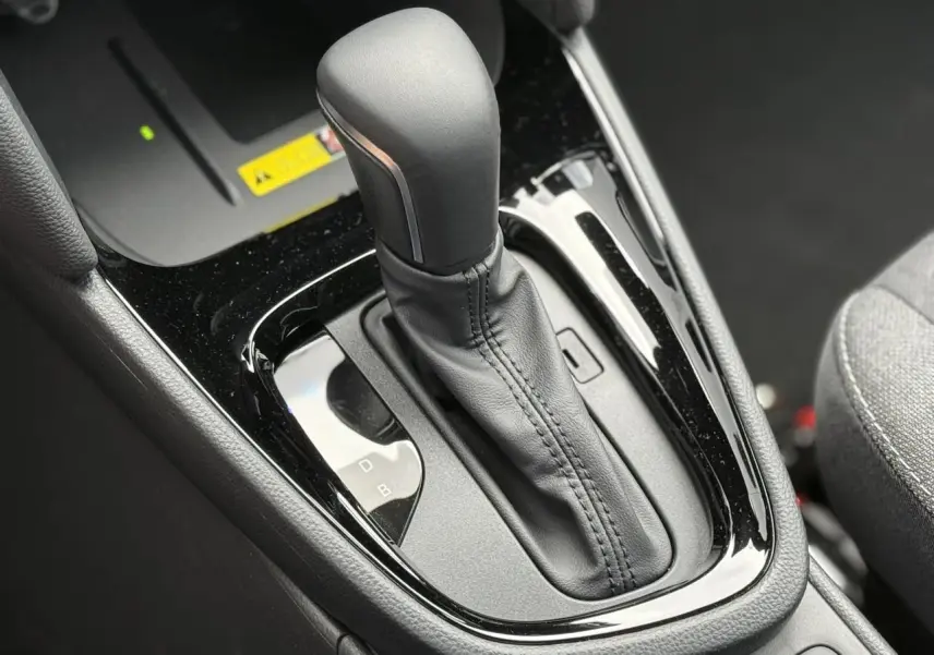 Gros plan sur la commande de boîte automatique cuir noir de la Toyota Yaris Cross 1.5 Hybrid 116 Design.