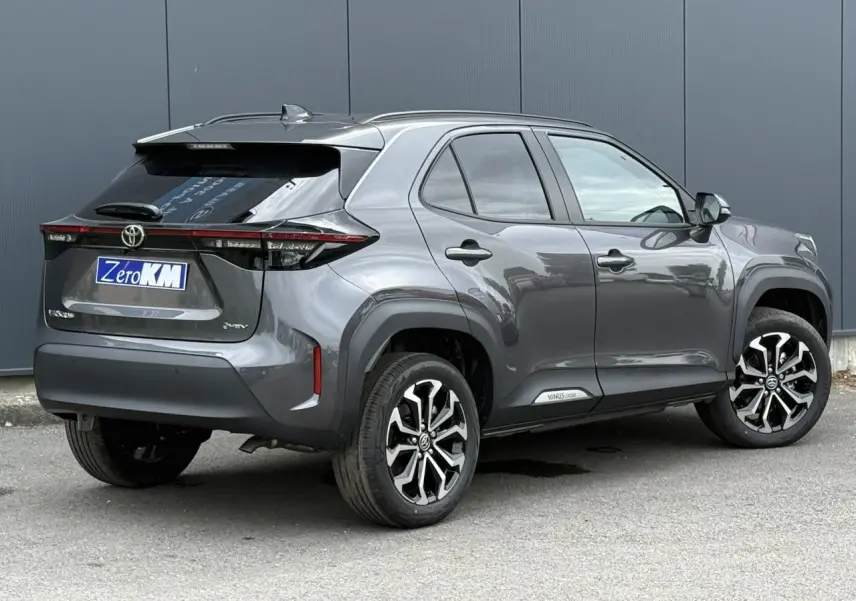 Toyota Yaris Cross gris Atlas en 3/4 arrière droit, avec jantes alliage noires et toit noir contrasté.