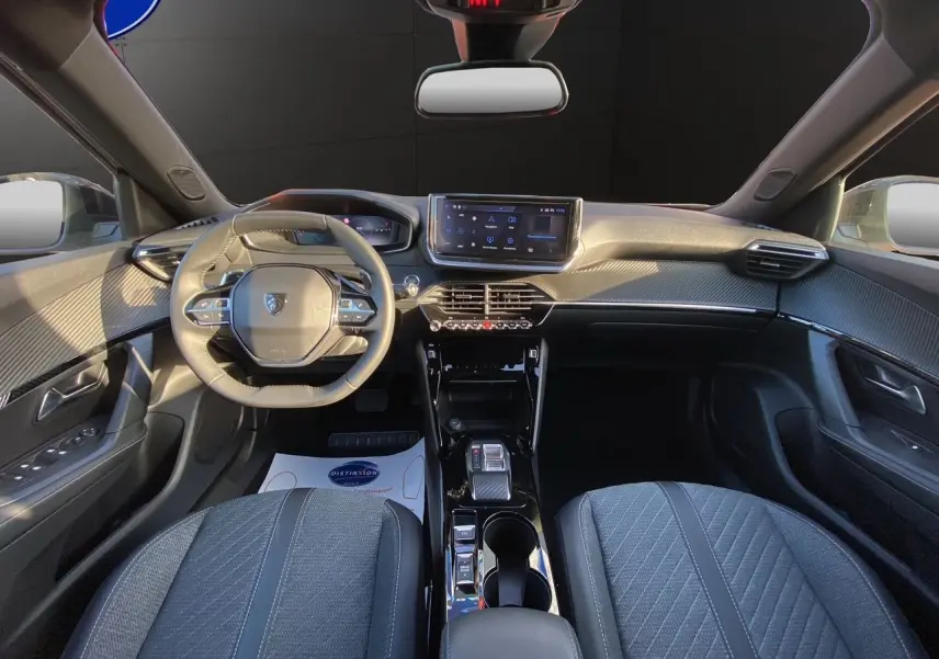 Intérieur du Peugeot 2008 2024 en gris, vue frontale du tableau de bord avec volant compact et écran tactile central.