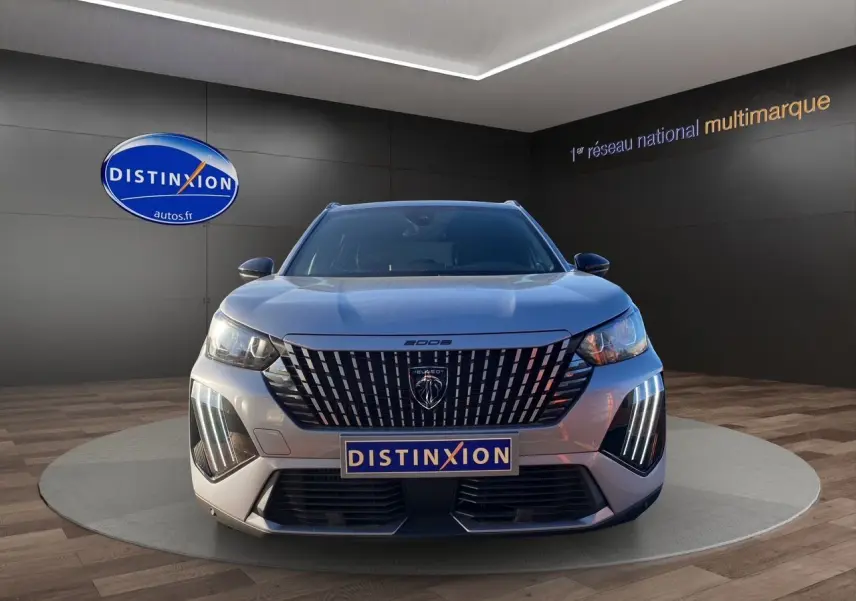 Vue frontale du Peugeot 2008 gris Artense avec sa calandre verticale distinctive et feux LED en éclairage diurne.