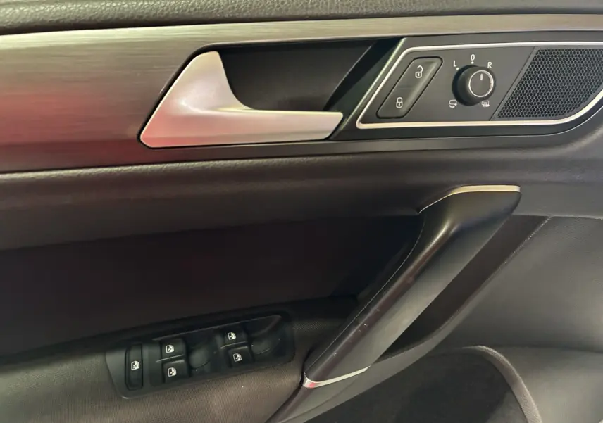 Gros plan sur la porte côté gauche intérieure grise et noire de la Volkswagen Golf Sportsvan 2019 avec commandes de vitres et rétroviseurs.