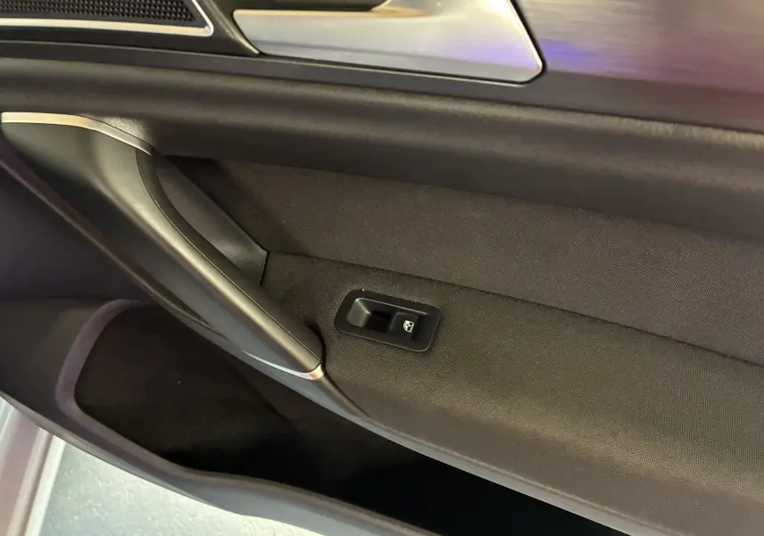 Détail de la porte côté gauche d'une Volkswagen Golf Sportsvan gris 2019, avec commande de lève-vitre intégrée.