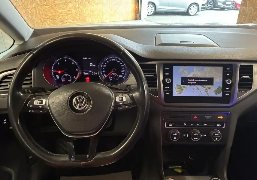 Vue intérieure du tableau de bord et volant noir d'une Volkswagen Golf Sportsvan 2019 avec écran tactile et commandes au volant.
