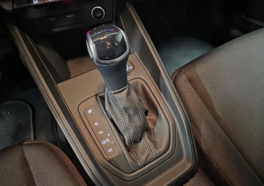 Gros plan sur la console centrale de l'Audi A1 Sportback 2024, levier de boîte automatique en cuir noir.