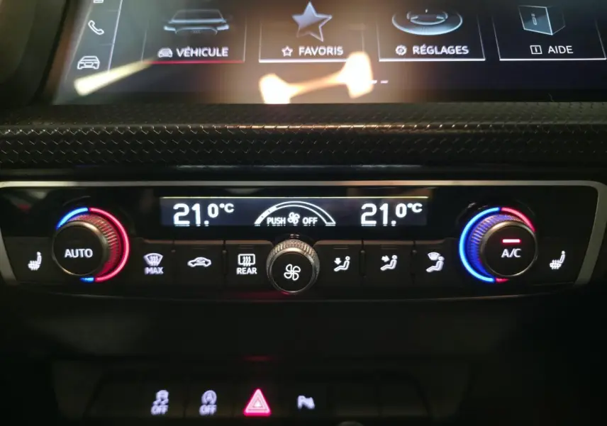 Gros plan sur la console de climatisation automatique double zone de l'Audi A1 Sportback 2024 avec réglages numériques à 21°C.