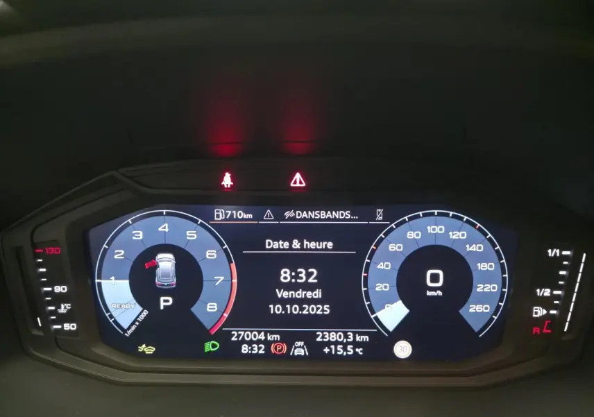 Affichage numérique du tableau de bord de l'Audi A1 Sportback gris, montrant vitesse, compte-tours et informations de conduite.