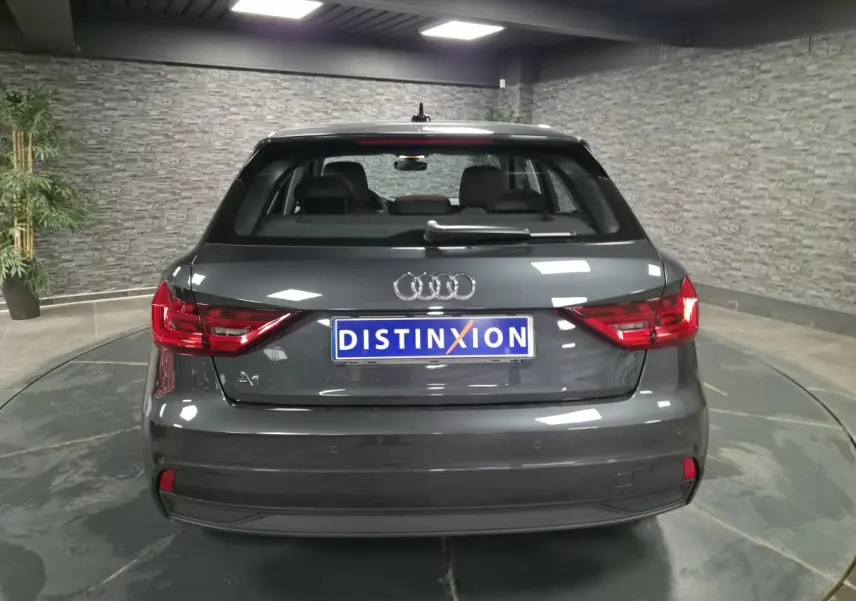 Vue arrière d'une Audi A1 Sportback gris Manhattan avec feux LED et logo distinctif au centre.