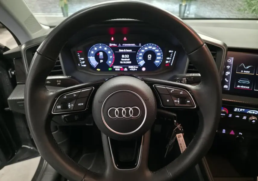 Vue frontale du volant cuir noir multifonctions et du tableau de bord digital de l'Audi A1 Sportback gris 2024.