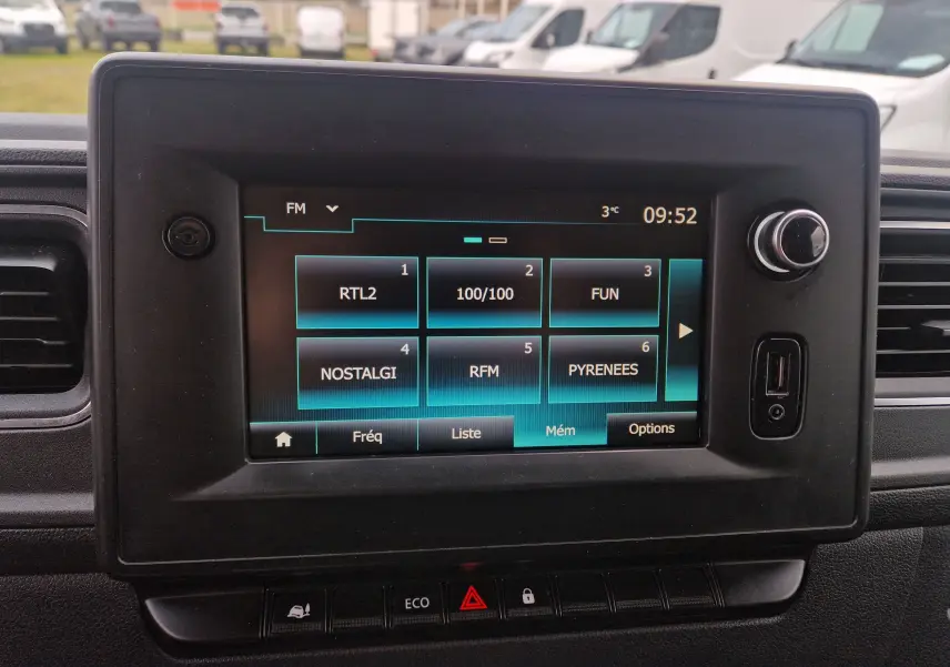 Écran tactile central du Renault Master blanc 2020 affichant les stations radio FM avec commandes autour.