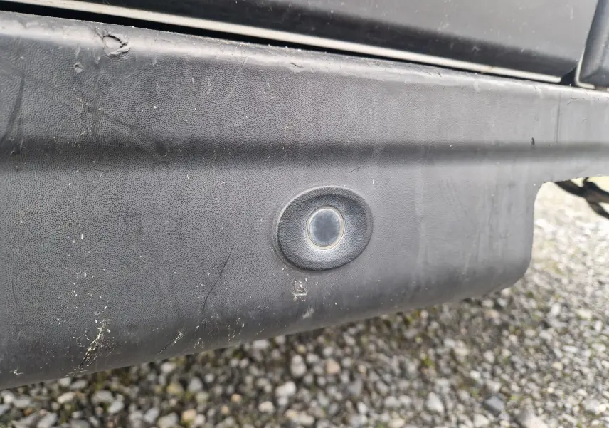 Gros plan sur un capteur de recul noir intégré au pare-chocs arrière d'un Renault Master blanc de 2020.
