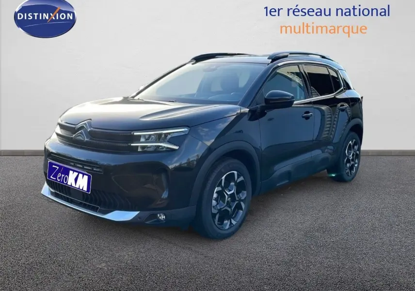 Citroën C5 Aircross noir perla metal en vue 3/4 avant droit, avec jantes bi-ton et barres de toit visibles.
