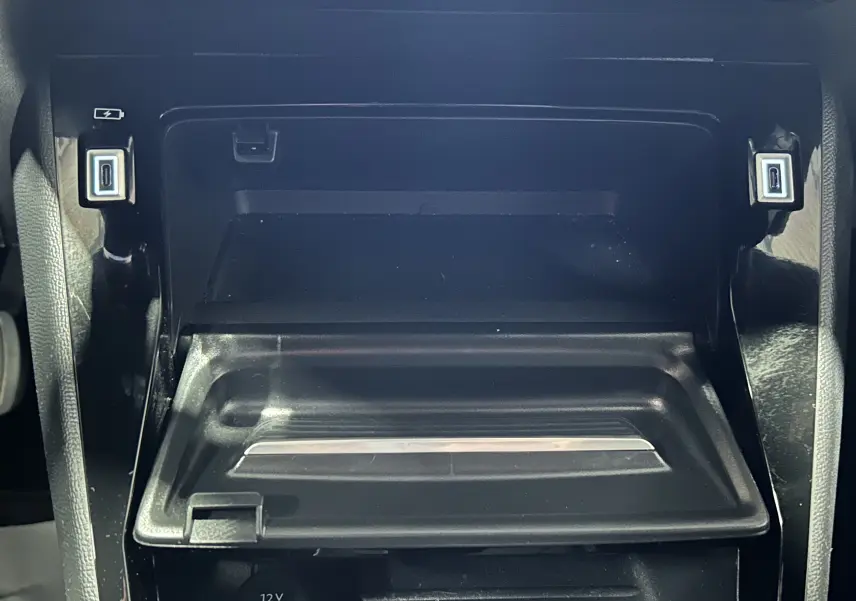 Gros plan sur la console centrale noire du Peugeot 2008 Allure Hybrid 145, avec deux ports USB visibles.