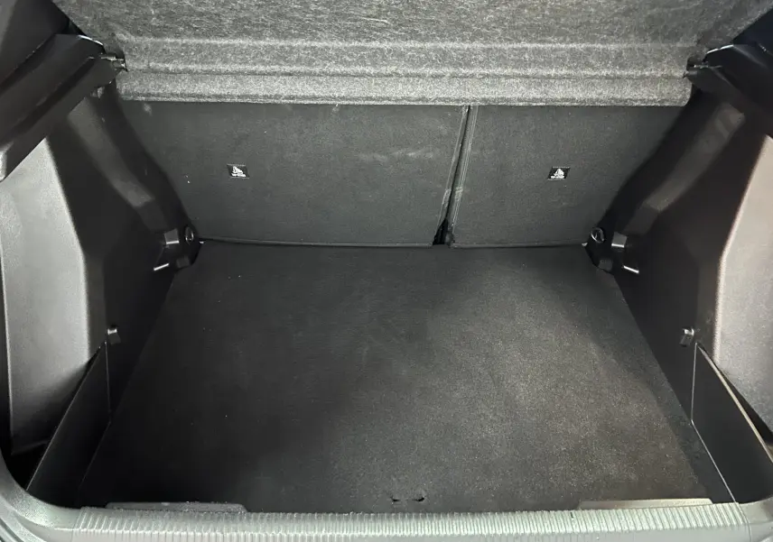 Coffre vide de Peugeot 2008 Allure Hybrid 145 en vue intérieure, montrant l'espace de chargement en tissu noir.