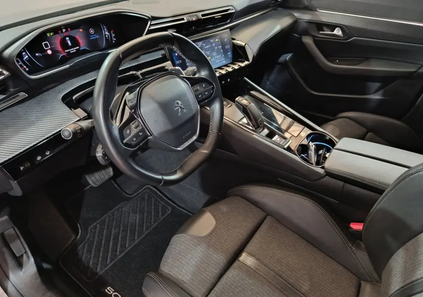 Vue intérieure côté conducteur de la Peugeot 508 gris clair, avec tableau de bord numérique et écran tactile central.