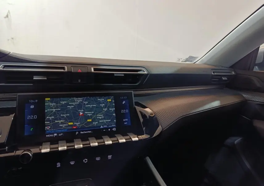 Vue intérieure côté passager du tableau de bord noir avec écran tactile de navigation et finition carbone du Peugeot 508 gris clair.