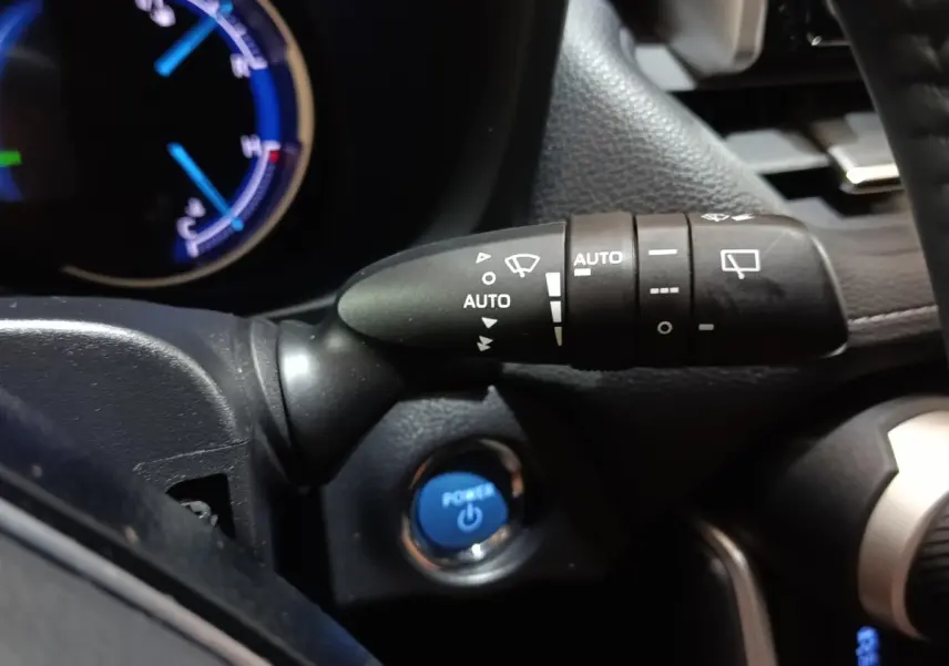 Gros plan sur la commande d’essuie-glace à gauche du volant dans l’habitacle noir du Toyota RAV4 hybride 2021.