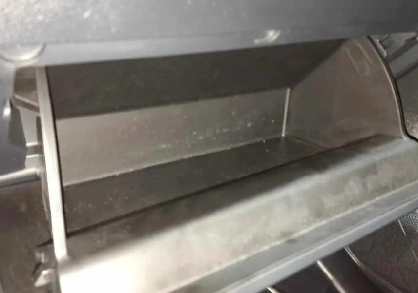 Vue rapprochée de la boîte à gants ouverte du Toyota RAV4 hybride 2021, intérieur noir sans contenu visible.
