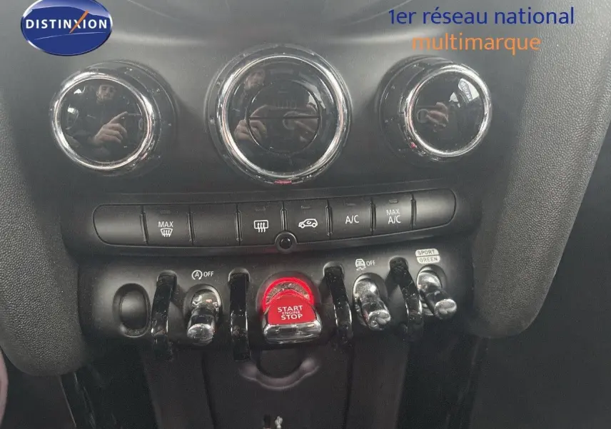 Vue rapprochée du tableau de bord de la MINI 2023 en rooftop grey, mettant en valeur les commandes de climatisation et le bouton start/stop rouge.