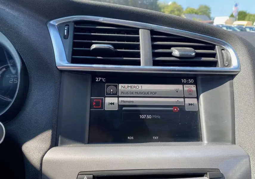Tableau de bord de Citroën C4 2015 avec écran tactile radio et ventilation centrale en vue frontale rapprochée.