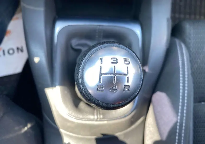 Le levier de vitesses manuel en gros plan de la Citroën C4 rouge Millenium de 2015, montrant les rapports 1 à 5 et la marche arrière.