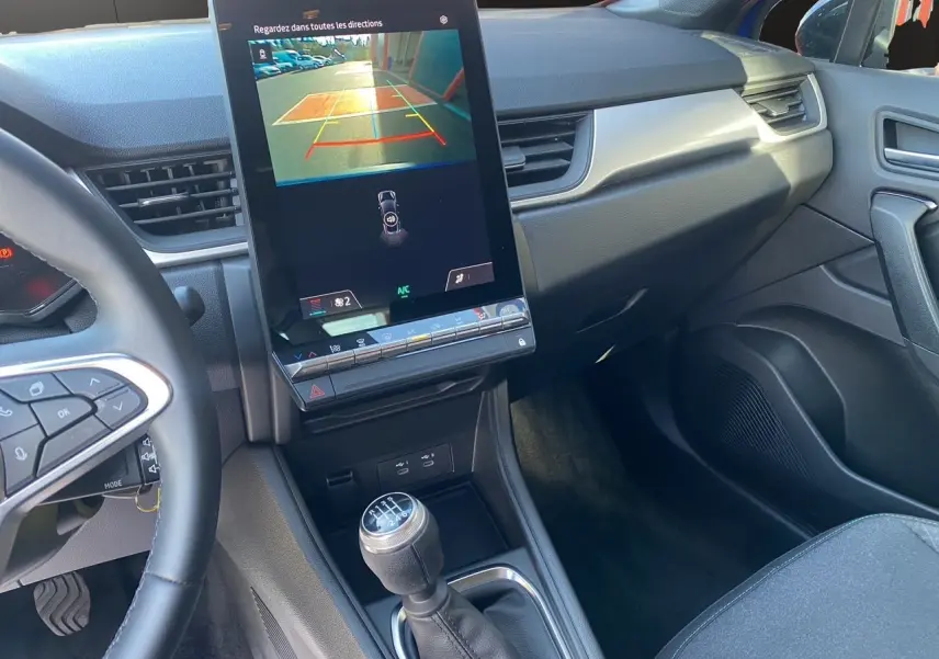Intérieur du Renault Captur 2024 TCE 90 Evolution, vue sur la console centrale avec écran tactile et levier de vitesses manuel.
