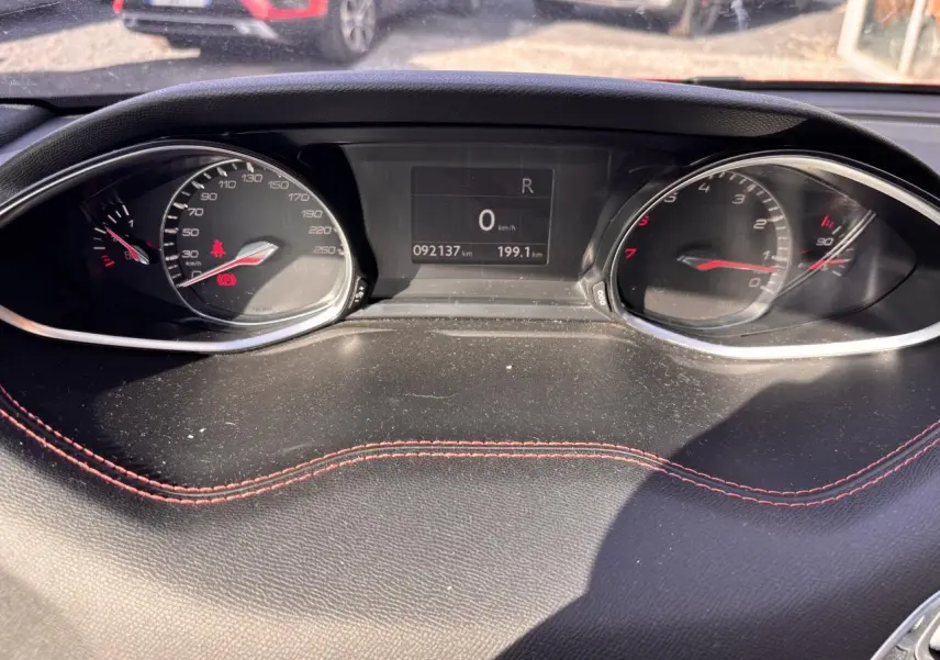 Tableau de bord de Peugeot 308 GT Line 2016 avec compteur digital et surpiqûres rouges sur cuir noir.