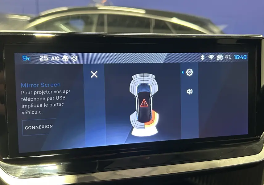 Écran tactile intérieur du Peugeot 2008 Allure Hybrid 145 montrant l'alerte radar avant et arrière en fonctionnement.