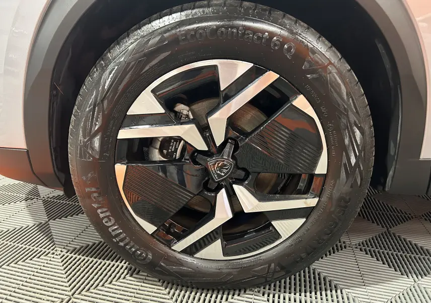 Gros plan sur la roue avant droite du Peugeot 2008 gris 2025 avec jante alliage noire et argentée au design moderne.