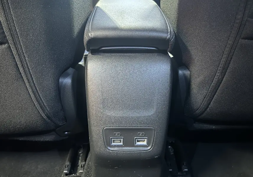 Prise USB Type-C et USB Type-A au dos de la console centrale d'un Peugeot 2008 gris hybride 2025, vue intérieure rapprochée.