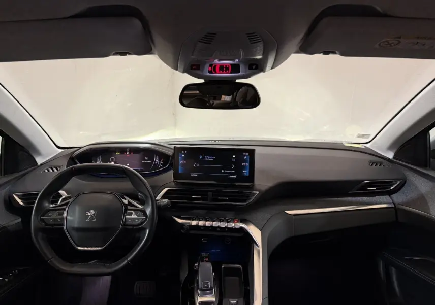 Vue intérieure avant du Peugeot 5008 gris clair 2021, mettant en valeur le tableau de bord numérique et l’écran tactile central.