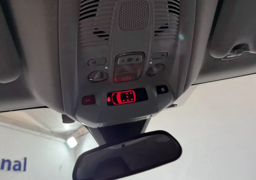 Vue intérieure du plafonnier de la Peugeot 5008 gris clair, avec commandes lumineuses et rétroviseur central visible.