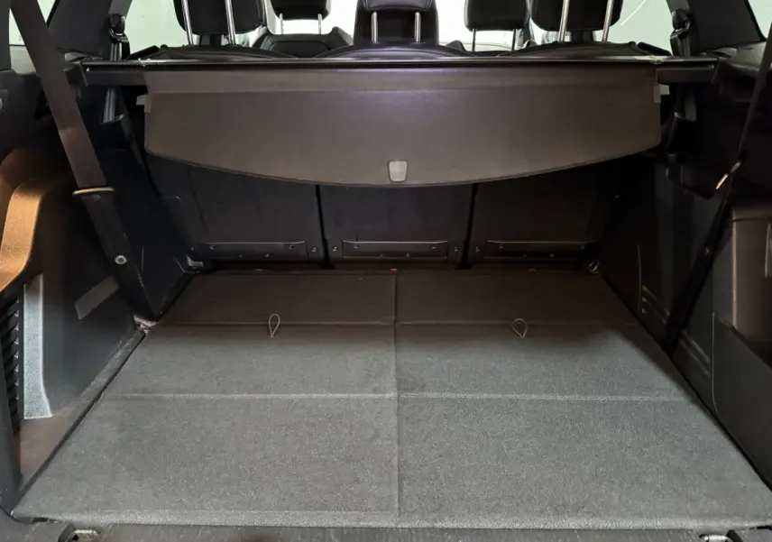 Coffre ouvert du Peugeot 5008 gris clair, vue de l'arrière montrant la grande capacité et la tablette cache-bagages.