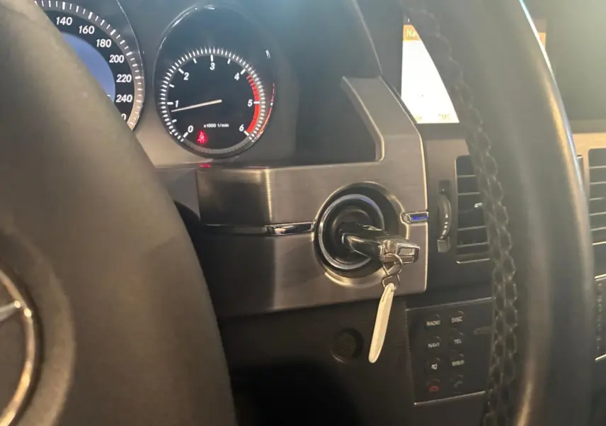 Vue intérieure rapprochée du tableau de bord noir du Mercedes GLK 220 CDI avec clé insérée dans le contacteur.