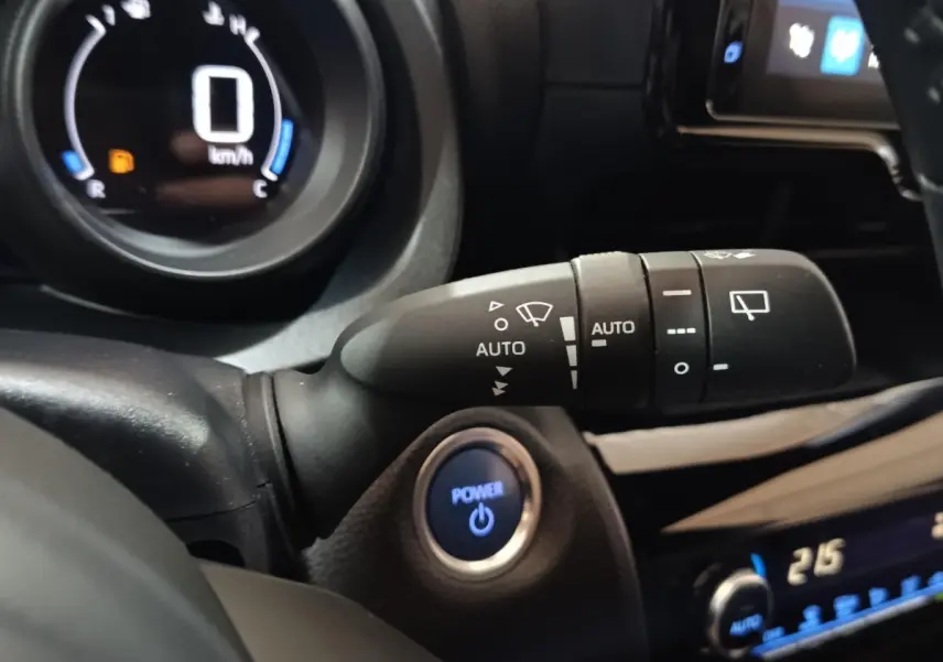 Détail intérieur du Toyota Yaris Cross 2022 montrant le bouton Power bleu et la commande d’essuie-glace automatique.