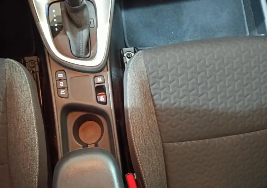 Vue plongeante sur la console centrale et les sièges avant gris du Toyota Yaris Cross 1.5 Hybrid 2022 avec boîte automatique.