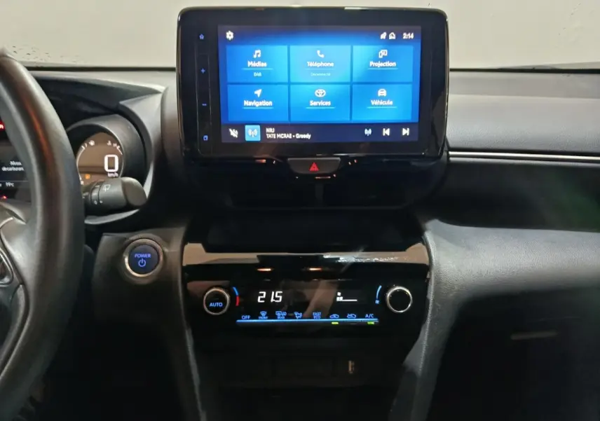 Vue intérieure centrée sur le tableau de bord et l’écran tactile de la Toyota Yaris Cross 2022 gris foncé.