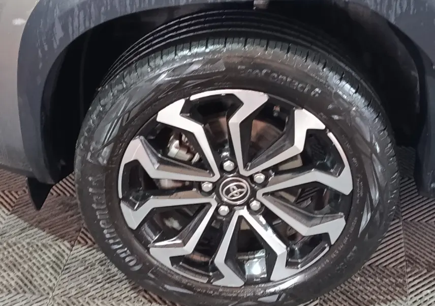 Gros plan sur la roue avant droite du Toyota Yaris Cross gris foncé avec jante alliage noire et argentée.