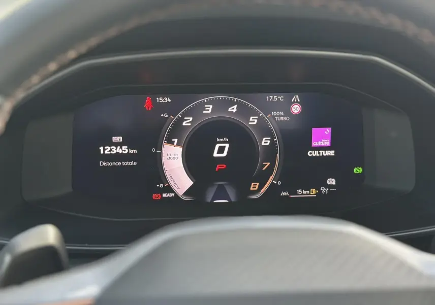 Tableau de bord numérique du CUPRA Formentor blanc, affichant le compteur à 0 km/h et 12 345 km au total.